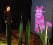 A visitor talks to the Cheshire Cat.